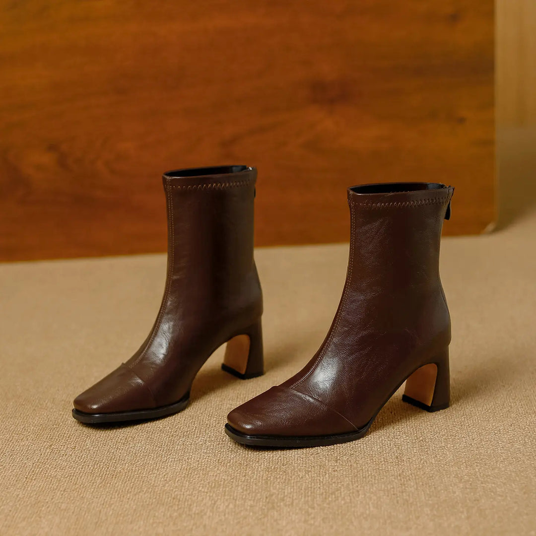Kaelen brown square-toe ankle boots with a block heel and rear zipper closure, shown from a three-quarter angle on a textured carpet.
