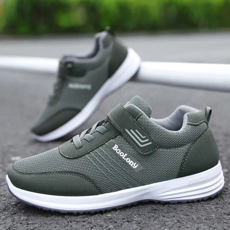 Pair of Kaelen breathable mesh sneakers in dark grey with a white midsole and grey rubber outsole, featuring a hook-and-loop strap closure and reflective side stripes.