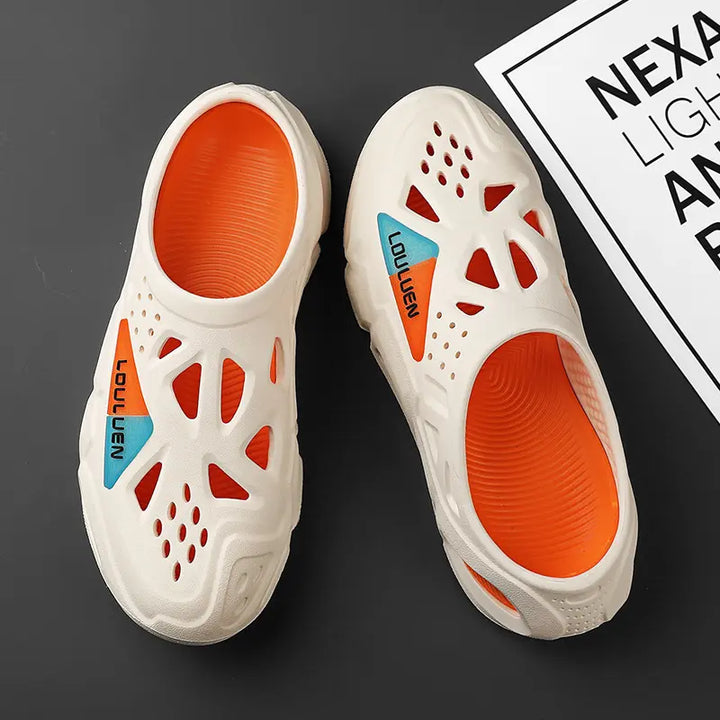 A pair of cream beige Kaelen EVA clogs with bright orange interiors, featuring ventilation cut-outs and split orange/blue &