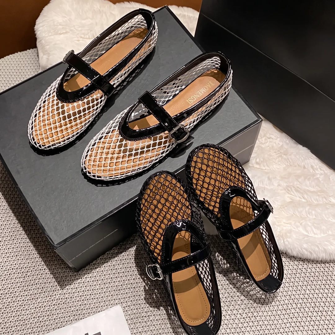 Kaelen white and black mesh ballet flats with patent Mary Jane straps and silver buckles, displayed with a black shoe box on a textured surface.