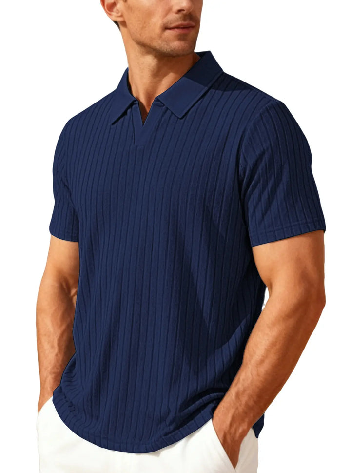 Man wearing a Kaelen navy blue textured knit polo shirt with a relaxed fit and an open V-neck collar, shown from a three-quarter angle.