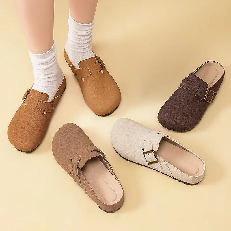 Kaelen retro buckle mules in multiple suede-effect colors, with a pair shown worn on feet with white socks. Features include a round toe, flat sole, and antique brass buckle strap.