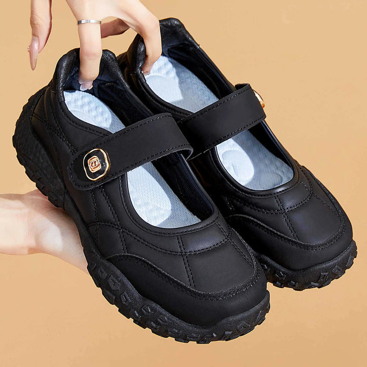 Kaelis black quilted round-toe Mary Jane flats with an adjustable hook-and-loop strap and a decorative gold-tone buckle, featuring a chunky rubber sole.