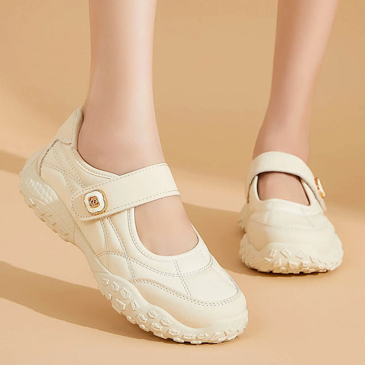 Kaelis quilted Mary Jane flats with a hook-and-loop strap in cream white, shown on feet with a chunky rubber sole and decorative gold buckle.