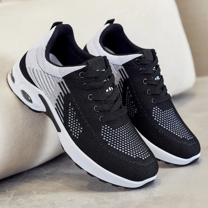 Kaelix breathable knit trainers in black and white with abstract stripe pattern and visible air cushioning heel, shown in a three-quarter view.
