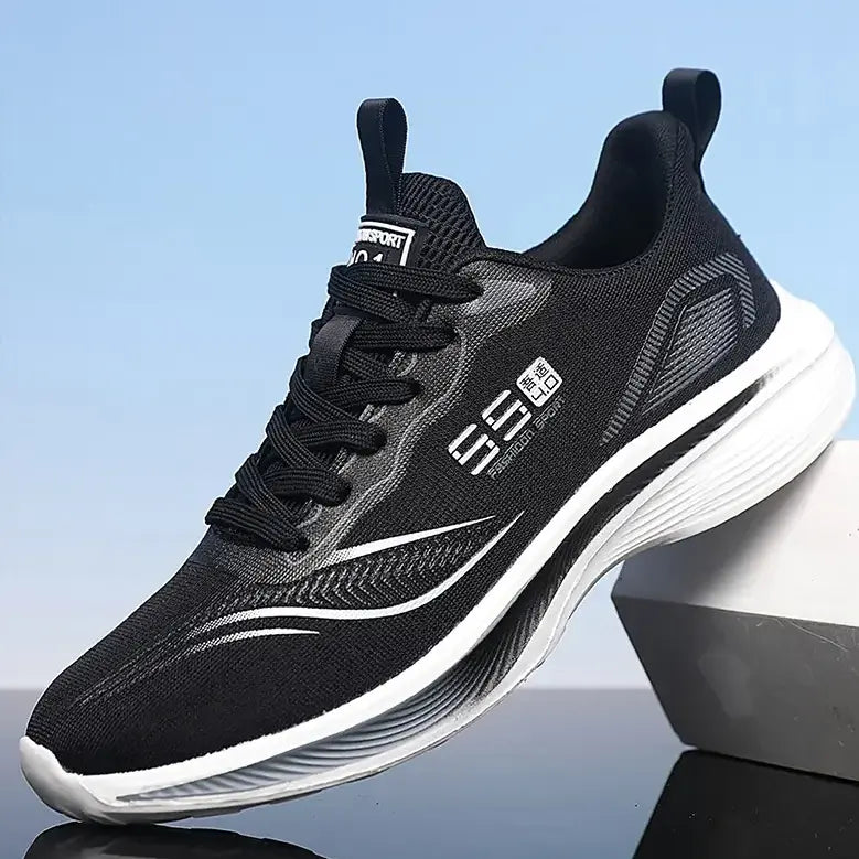 Black Kaelos lightweight mesh athletic sneakers for women, featuring a white sculpted wave sole and lace-up closure. The shoe displays a &