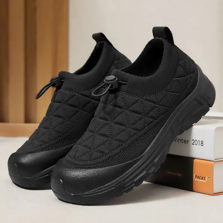 Kaelos black quilted knit slip-on sneakers with bungee laces, cream rubber toe cap, and thick white platform sole.