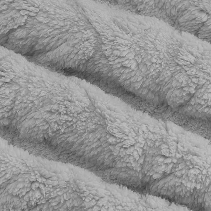 Close-up view of the soft, textured, high-pile fleece fabric in a light grey color, showcasing the distinct chevron pattern and plush feel of the Kaelum hoodie.
