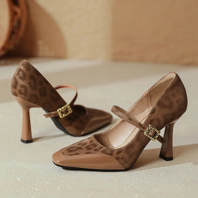 Kaelum patent leather Mary Jane heels in leopard print brown, featuring a square toe, sculptural block heel, and decorative gold-tone buckle strap.