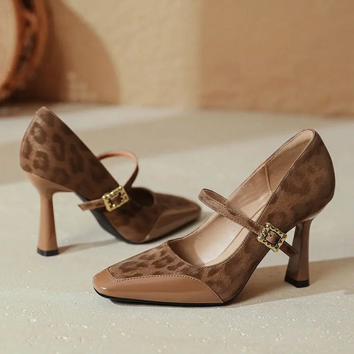 Kaelum patent leather Mary Jane heels in leopard print brown, featuring a square toe, sculptural block heel, and decorative gold-tone buckle strap.