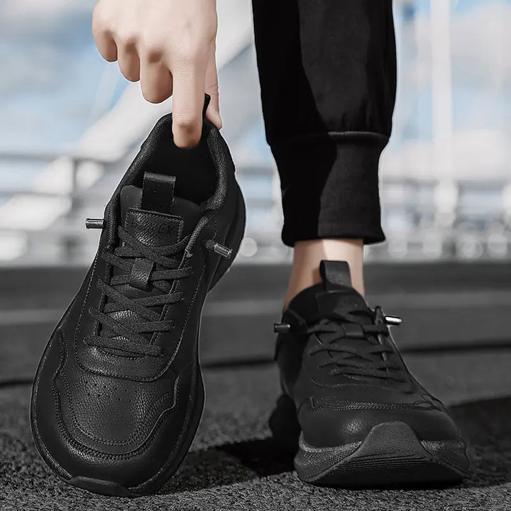 Close-up of black Kalyx wide fit breathable trainers on a person&