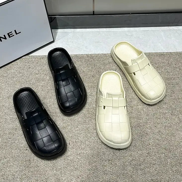 Two pairs of Kalyx EVA clogs, one in black and one in apricot, showcasing their woven strap design and comfortable slip-on silhouette on a textured rug.