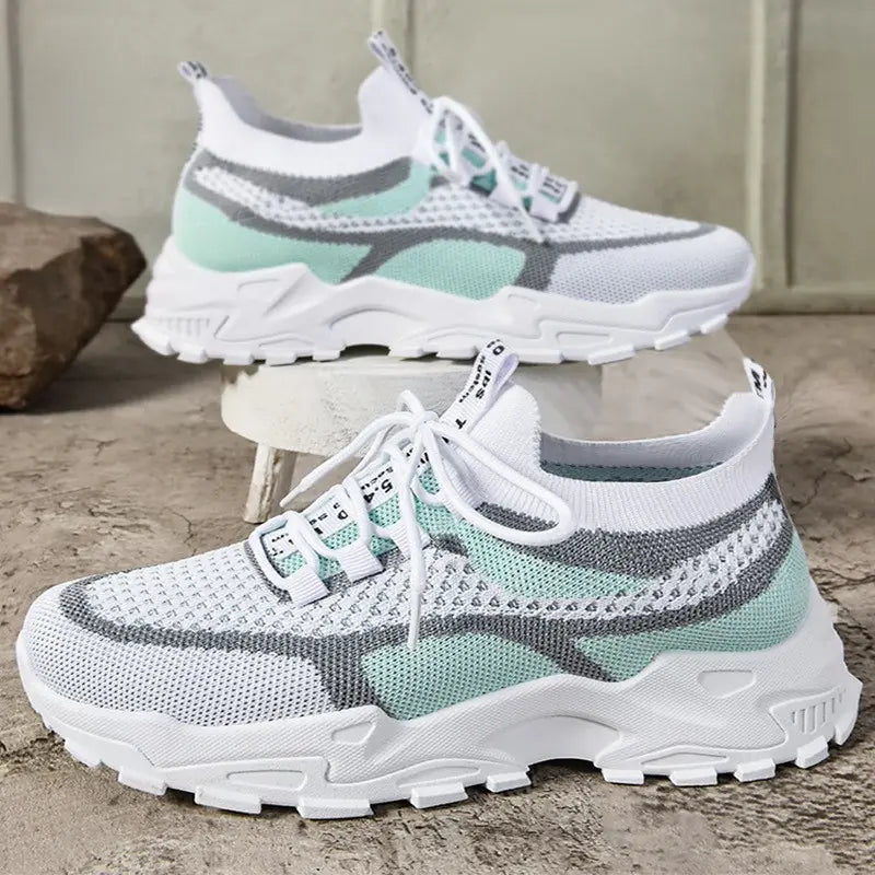 Kalyx women's breathable mesh sneakers in white with abstract pink and grey knit patterns, featuring a sock-like collar and a sculpted chunky white sole, shown from a three-quarter angle.