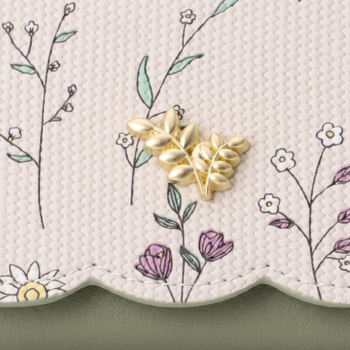 Close-up view of a Kezel PU leather wallet showcasing a delicate floral print with light green stems and white daisies, accented by a gold-tone metal flower charm.