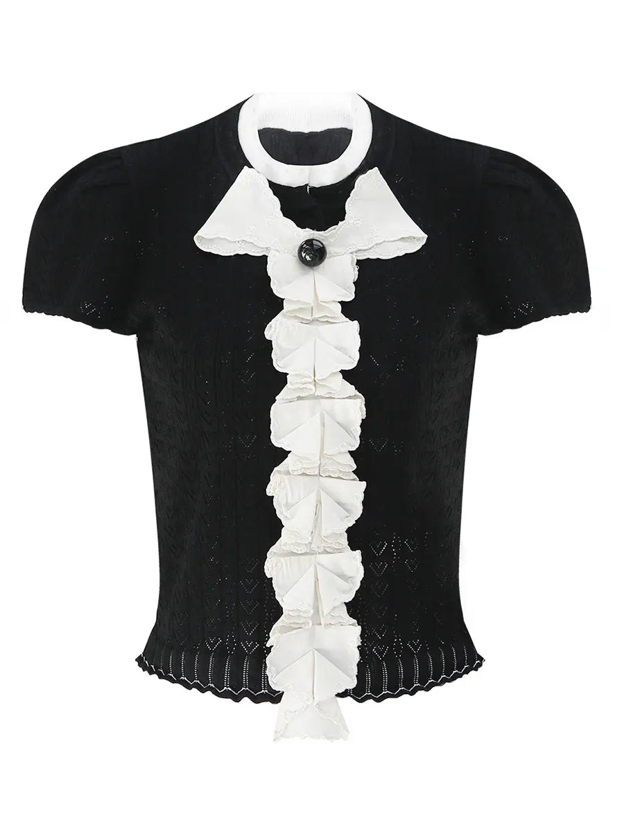 Kezh black fine-gauge knit short sleeve top with cascading white ruffles, a black bow accent, and a scalloped hem, shown from the front.
