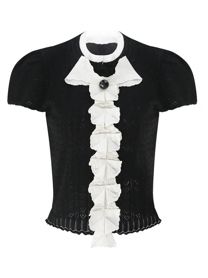 Kezh black fine-gauge knit short sleeve top with cascading white ruffles, a black bow accent, and a scalloped hem, shown from the front.