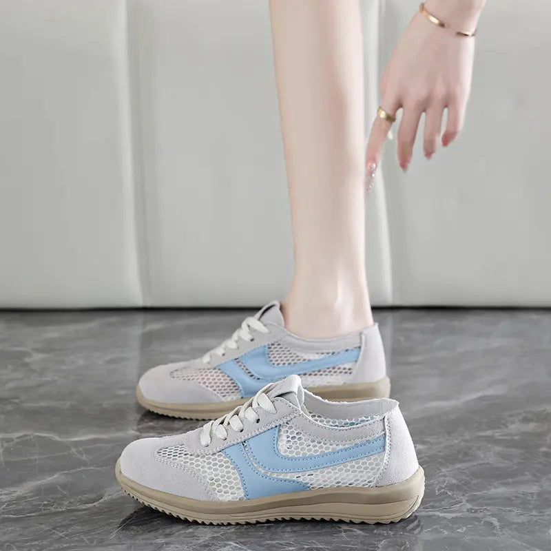 Light grey Khyzra breathable mesh trainers with light blue accent stripes and suede-like overlays, shown on a model&