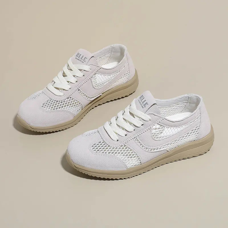 Two off-white breathable mesh trainers with suede-like accents and light beige soles, shown from a three-quarter angle on a neutral studio background.