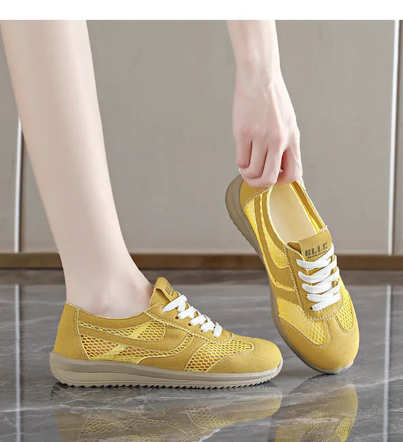 Yellow breathable mesh Khyzra trainers shown from a three-quarter angle with white laces and a subtle side stripe, on a person&