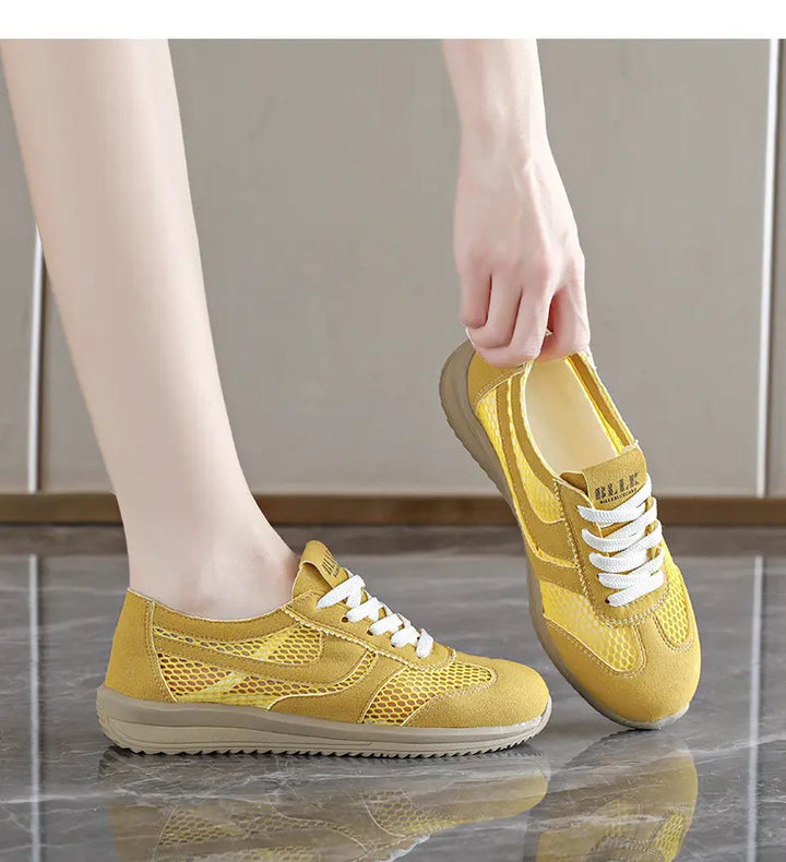 Yellow breathable mesh Khyzra trainers shown from a three-quarter angle with white laces and a subtle side stripe, on a person&