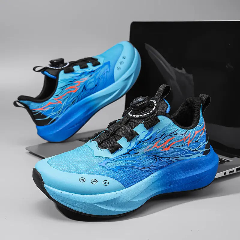 A pair of Korva kids' breathable mesh trainers in a gradient blue with dynamic orange and light blue flame graphics, featuring a dial-lace closure system and sculpted midsole.