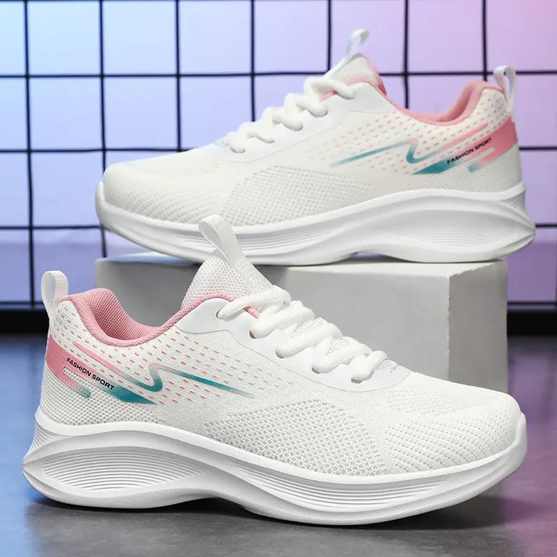 Pair of Kylos women's white breathable running shoes with pink and teal gradient accents and 'FASHION SPORT' text, presented on a studio background.