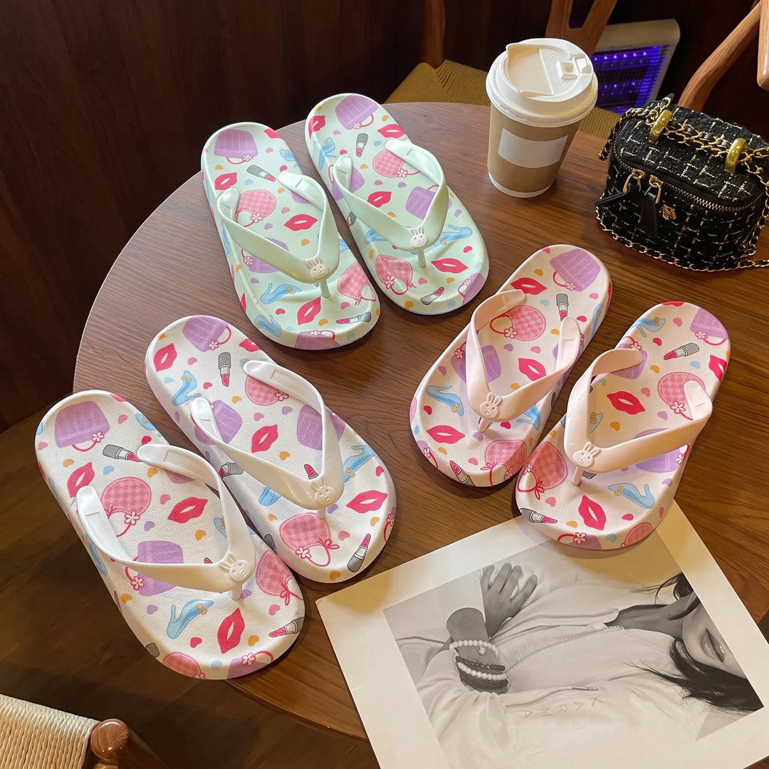 A flat lay arrangement of multiple pairs of Kythor platform flip-flops, showcasing pastel floral patterns and white bunny charms on pastel and white bases.