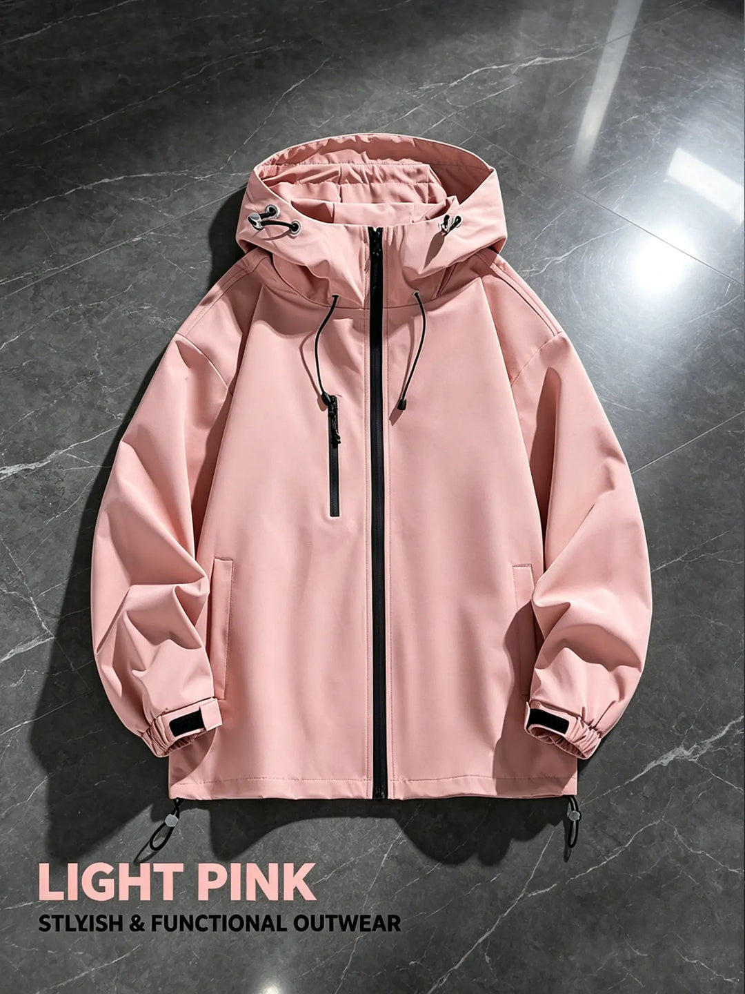 A light pink, hooded, full-zip performance jacket with adjustable cuffs and drawstring hood, displayed flat on a dark marble background.