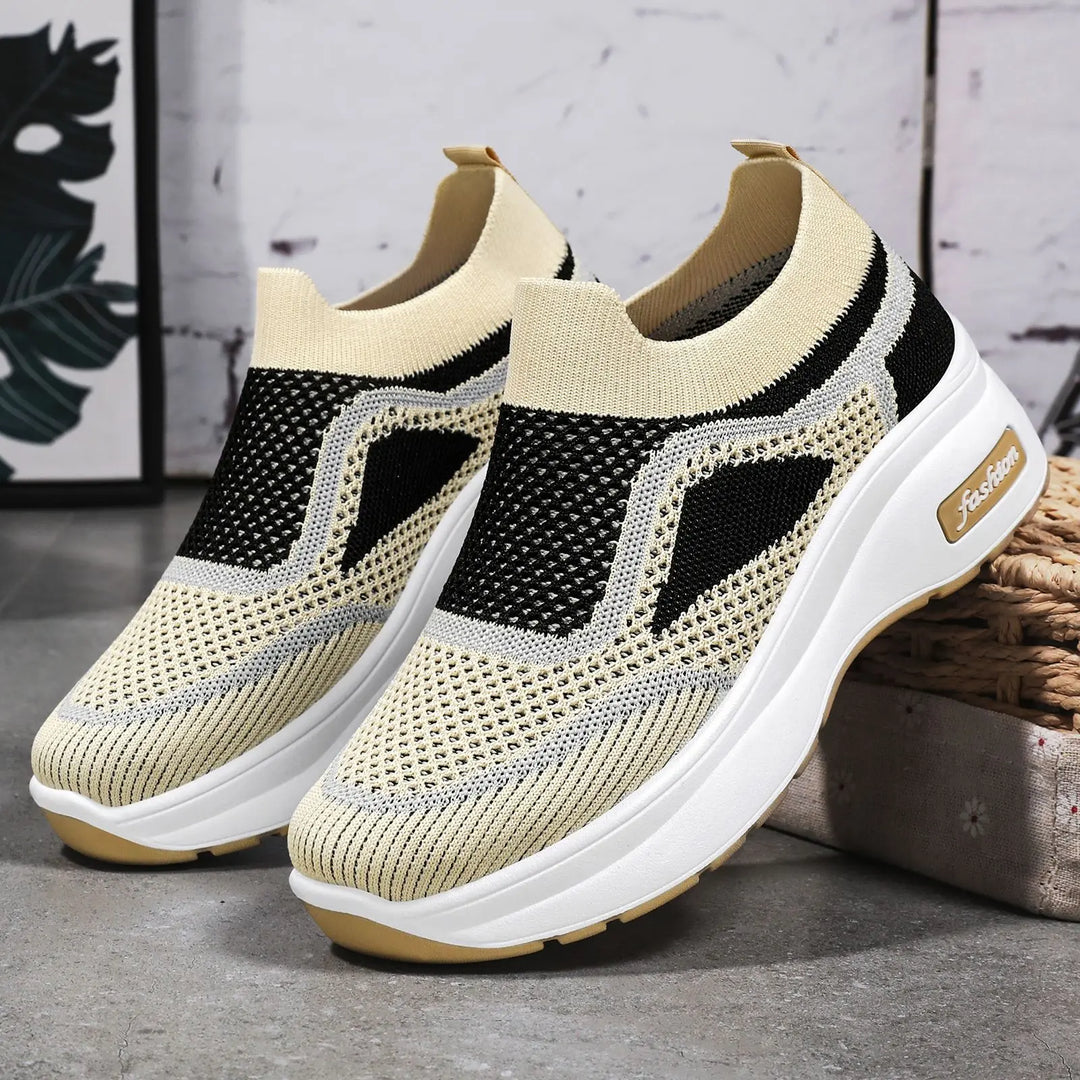 LyraFit breathable knit slip-on sneakers in warm beige with black and grey wavy stripe details and a white platform sole featuring the &