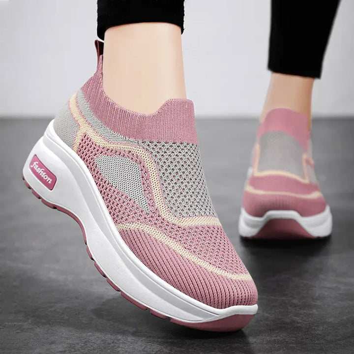 LyraFit breathable knit slip-on sneakers in vibrant pink with grey and cream accents, featuring a thick white platform sole with a &