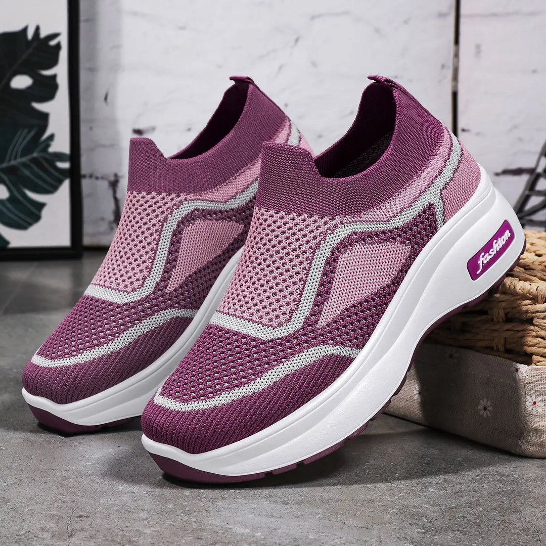 Pair of purple LyraFit breathable knit slip-on sneakers with wavy grey and pink accents and a thick white platform sole featuring a &