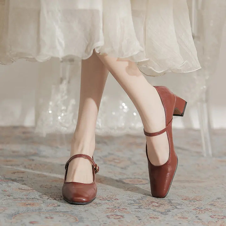 Warm chestnut brown faux leather Mary Jane block heels with square toe and single buckle strap, shown on a model&