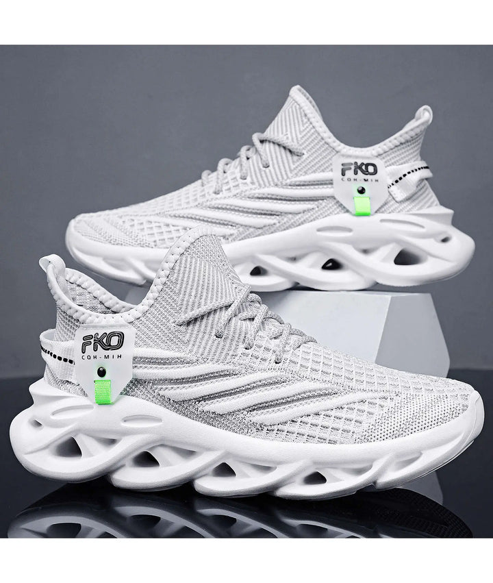 Two white and warm beige Mikari engineered knit sneakers shown from a three-quarter angle, featuring sculpted light tan soles with geometric cut-outs and a bright lime green tag.