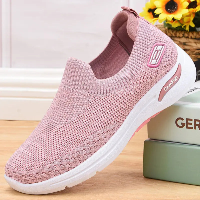 Nuvell women's slip-on knit sneakers in rose quartz pink, featuring a breathable mesh upper, white Comfort-branded midsole, and pink-accented rubber outsole.