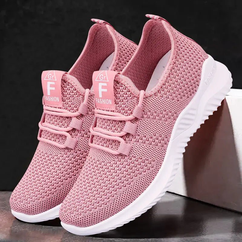 Nymra women's breathable mesh trainers in soft pink, featuring a white sole, lace-up closure, and 'Gr F FASHION' tongue labels.