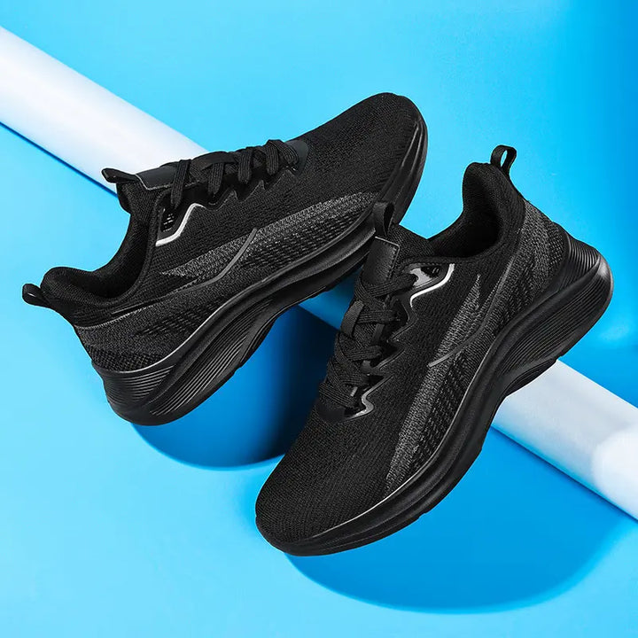 Pair of black Nyrvix lightweight breathable running shoes shown from a three-quarter angle on a blue studio background.