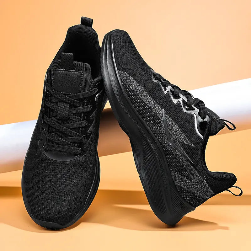 Pair of Nyrvix black lightweight breathable running shoes shown from a three-quarter angle with a sculpted white foam midsole and dark grey outsole.