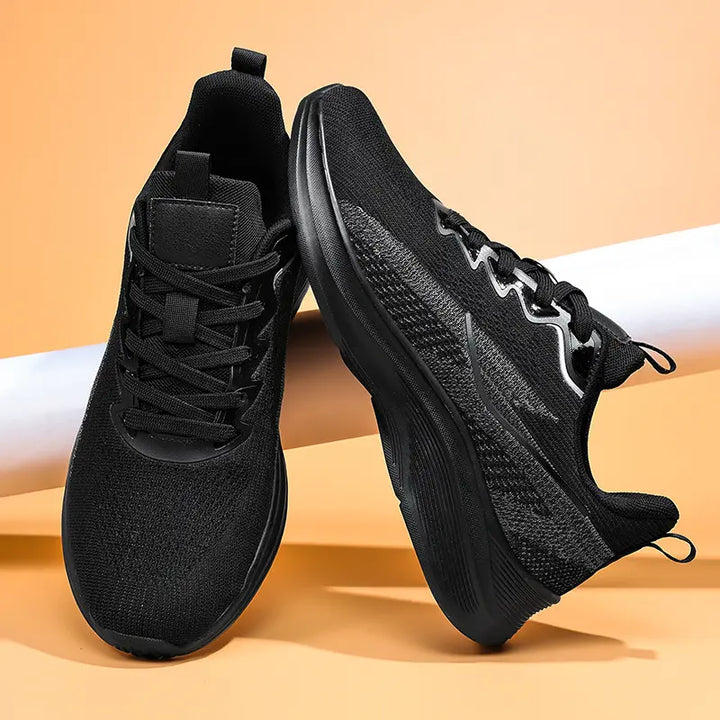 Pair of Nyrvix black lightweight breathable running shoes shown from a three-quarter angle with a sculpted white foam midsole and dark grey outsole.