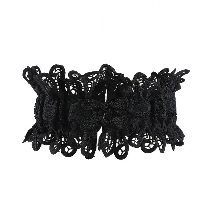 Black intricate floral lace statement belt with satin ribbon ties, cinching the waist with a decorative avant-garde design.