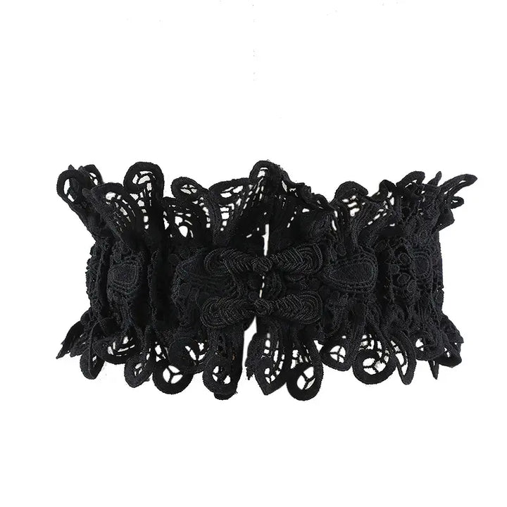 Black intricate floral lace statement belt with satin ribbon ties, cinching the waist with a decorative avant-garde design.