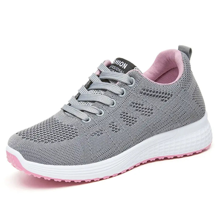 Grey knit low-top sneaker with a delicate pink geometric pattern, plush pink lining, white midsole, and vibrant pink rubber outsole, featuring lace-up closure.