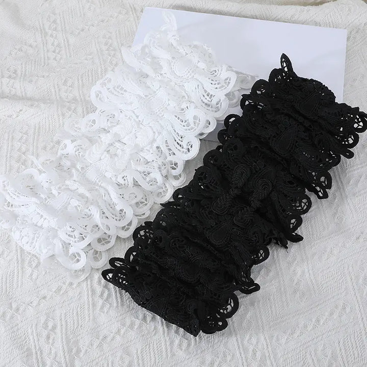 Two swatches of intricate floral lace trim, one in classic black and the other in pure white, showcasing the material for Nyxos lace belts and statement accessories.