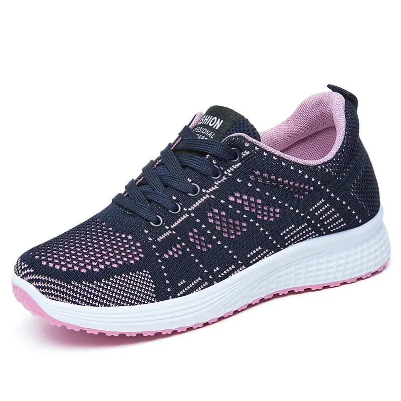 Navy blue and pink geometric knit low-top athletic sneakers with a white midsole and vibrant pink rubber outsole.