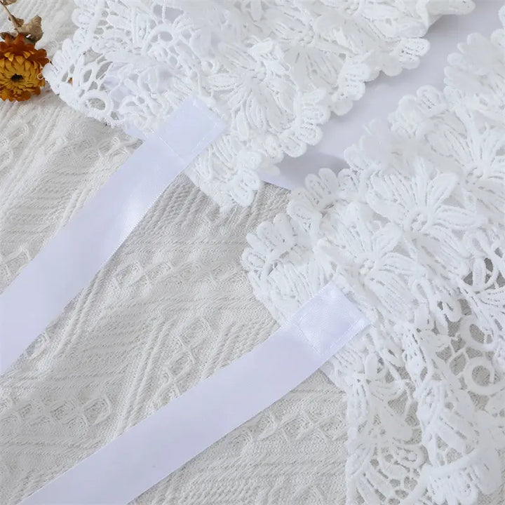 Close-up of white intricate floral lace cummerbund belt with smooth satin ribbon ties, showcasing delicate texture and craftsmanship.