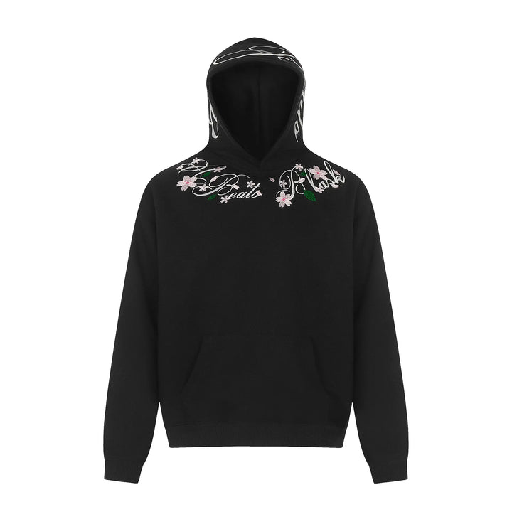 Black Orvela relaxed fit hoodie featuring intricate floral embroidery in pink and green with script text around the neckline, drop shoulders, and kangaroo pocket.