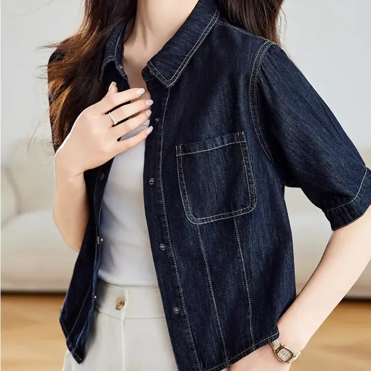 Ozkir dark wash cropped denim shirt jacket with short sleeves, pointed collar, twin chest pockets, and contrast stitching, worn by a model.