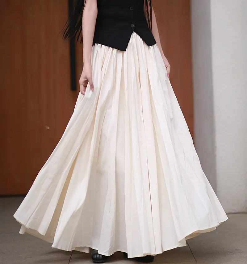 Voluminous A-line maxi skirt in a pale muted pastel pink, crafted from double-layer cotton with a gathered elastic waistband and a dramatic sweep.