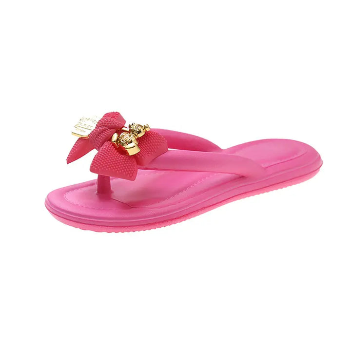 Bright pink EVA flip-flop featuring a textured bow embellished with a gold-tone teddy bear charm and clear beads on the strap.