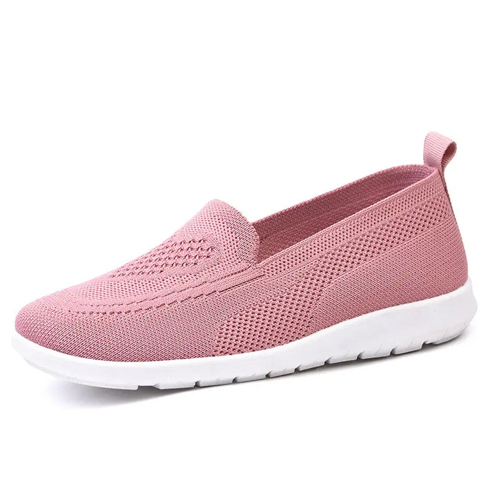 Pink breathable knit slip-on shoe with a subtle diamond weave pattern on the vamp and a white sole, shown from the side.