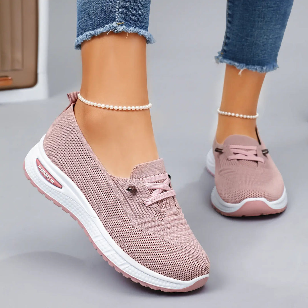 Zylos women's breathable pink knit slip-on casual trainers worn with distressed jeans and pearl anklets, showcasing the side three-quarter view and cushioned sole.